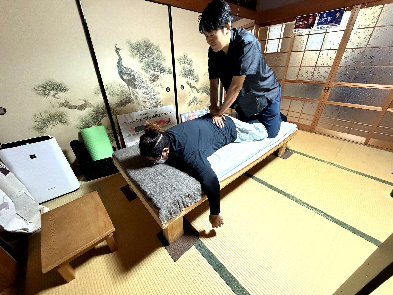 畳の施術室でカイロプラクティックの施術を受ける様子